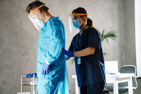Two Medical Workers Dressing Uniform Standing Indoors Wearing Robes Masks — Stock Photo, Image