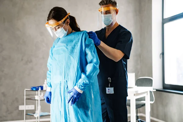 Deux Travailleurs Médicaux Habillés Uniforme Debout Intérieur Portant Des Peignoirs — Photo