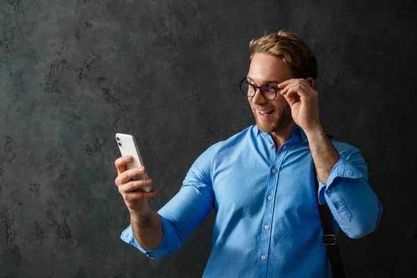 Portrait Smiling Man Blue Shirt Glasses Looking Phone While Standing — Stock Photo, Image