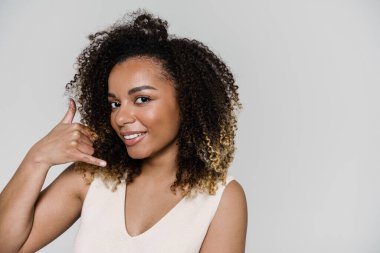 Gülümseyen bir kadının portresi. Gri stüdyoda dururken beni ara.