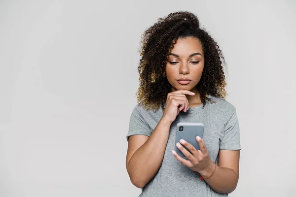 Retrato Uma Mulher Pensativa Olhando Para Telefone Enquanto Estava Estúdio — Fotografia de Stock