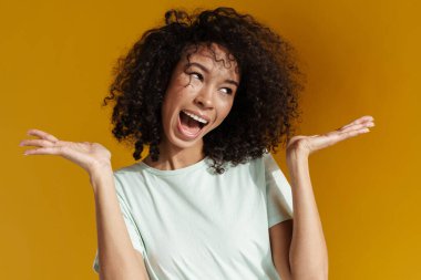 Genç Afrikalı kadın kahkahalarla gülüyor. Kopyalama alanını kahverengi duvarın üzerinde izole ediyor.