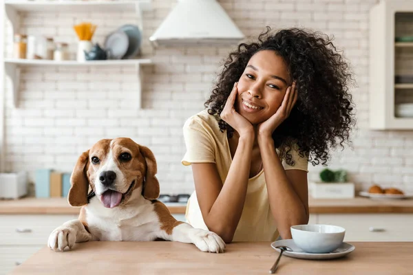 Glimlachende Jonge Afrikaanse Vrouw Leunend Een Aanrecht Met Haar Huisdier — Stockfoto