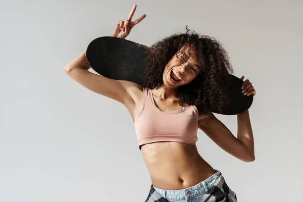 Ung Afrikansk Kvinna Snöar Fred Tecken Medan Poserar Med Skateboard — Stockfoto