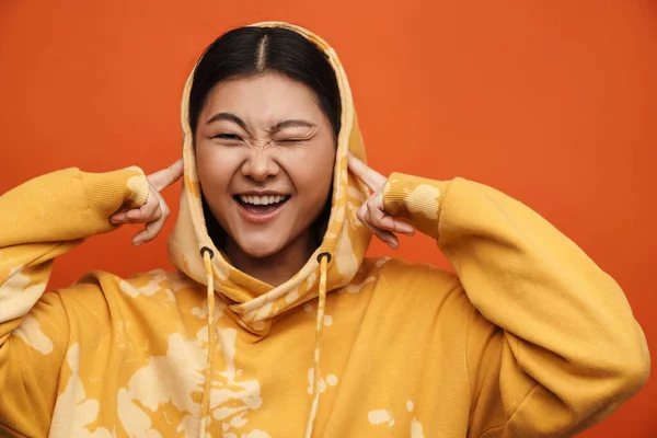 Asiatisches Teenie Mädchen Mit Kapuzenpulli Zwinkert Und Steckt Ihre Ohren — Stockfoto