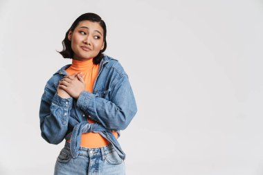 Genç Asyalı esmer kadın, beyaz arka planda el ele tutuşurken yüzünü buruşturuyor.