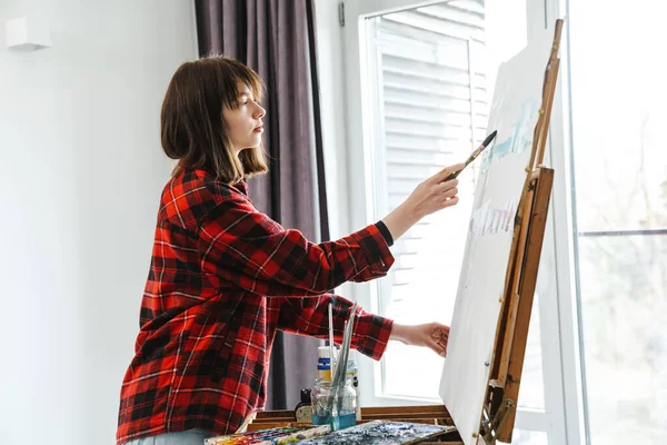 Ung Vit Kvinna Ledig Slitage Målning Duk Inomhus Nära Fönstret — Stockfoto