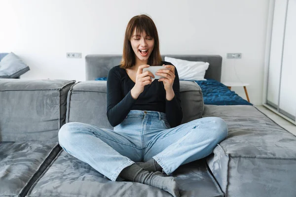 Lächelnde Junge Frau Mit Handy Während Sie Hause Auf Der — Stockfoto