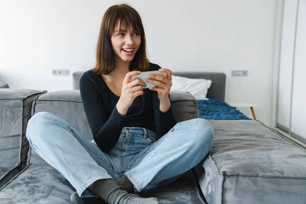 Lächelnde Junge Frau Mit Handy Während Sie Hause Auf Der — Stockfoto