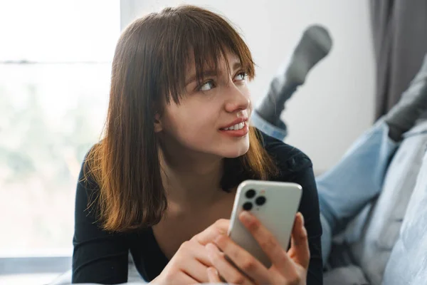 Glimlachende Jonge Vrouw Met Behulp Van Mobiele Telefoon Tijdens Het — Stockfoto