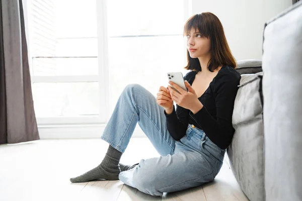Lächelnde Junge Frau Mit Handy Sms Während Sie Hause Auf — Stockfoto