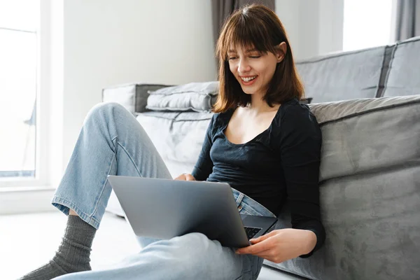 Uśmiechnięta Biała Kobieta Laptopem Siedząca Podłodze Domu — Zdjęcie stockowe