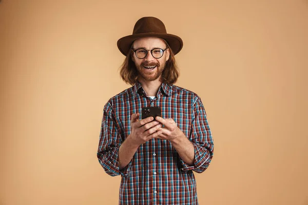 Sorrindo Gengibre Homem Vestindo Óculos Chapéu Usando Celular Isolado Sobre — Fotografia de Stock