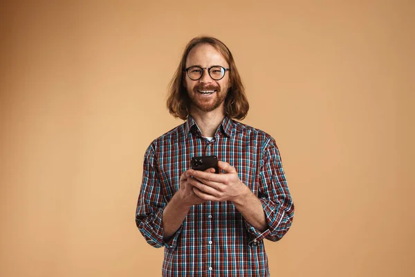 Weißer Ingwer Mann Mit Brille Lächelt Und Benutzt Handy Isoliert — Stockfoto
