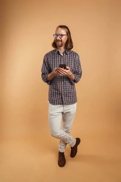 Weißer Ingwer Mann Mit Brille Lacht Und Benutzt Handy Isoliert — Stockfoto