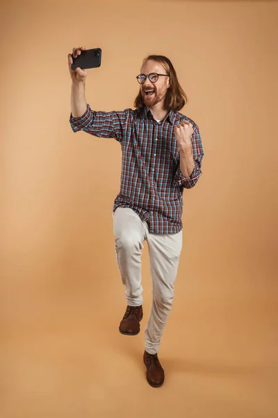 Hombre Jengibre Excitado Haciendo Gesto Ganador Mientras Toma Selfie Teléfono —  Fotos de Stock