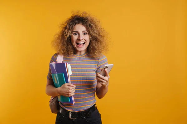 Szczęśliwa Młoda Studentka Plecakiem Stojącym Trzymając Podręczniki Telefon Komórkowy Tle — Zdjęcie stockowe