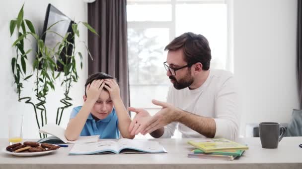 Vater Hilft Seinem Sohn Etwas Erklären Das Hause Tisch Sitzt — Stockvideo