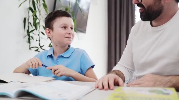 Widok Bliska Syna Odrabia Lekcje Podczas Gdy Jego Ojciec Pomaga — Wideo stockowe