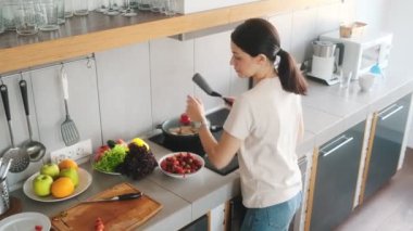 Evdeki mutfakta yemek pişiren bir kadının en iyi görüntüsü.