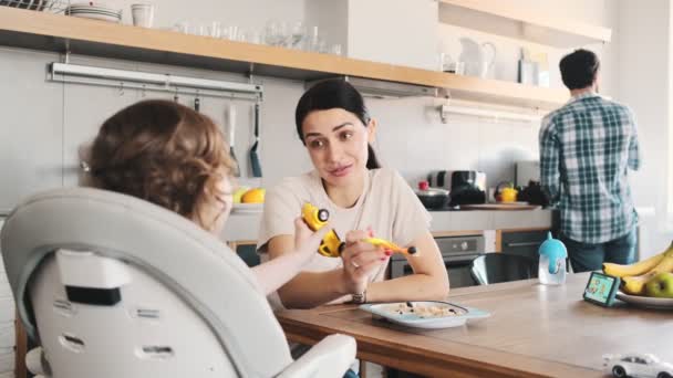 Güzel Bir Anne Çocuğunu Besliyor Mutfakta Çocuk Sandalyesinde Oturuyor — Stok video