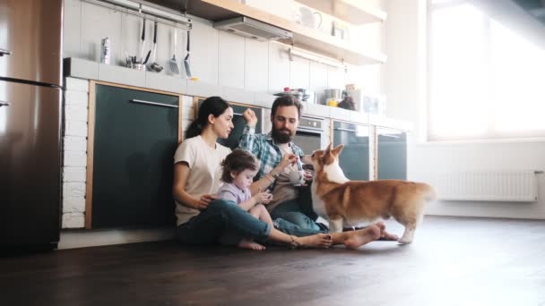 一个快乐的家庭和他们的狗一起坐在地板上 — 图库视频影像