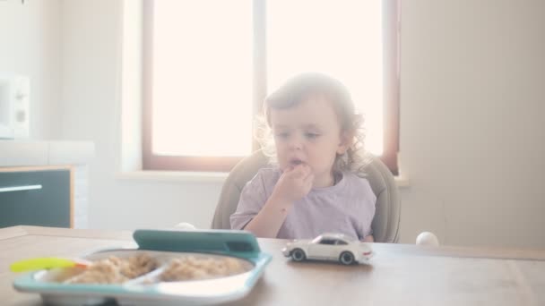 Küçük Bir Bebek Çocuk Koltuğunda Oturuyor Evdeki Mutfakta Cep Telefonunu — Stok video