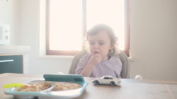 Een Kleine Baby Zit Kinderstoel Kijkt Mobiel Keuken Thuis — Stockvideo