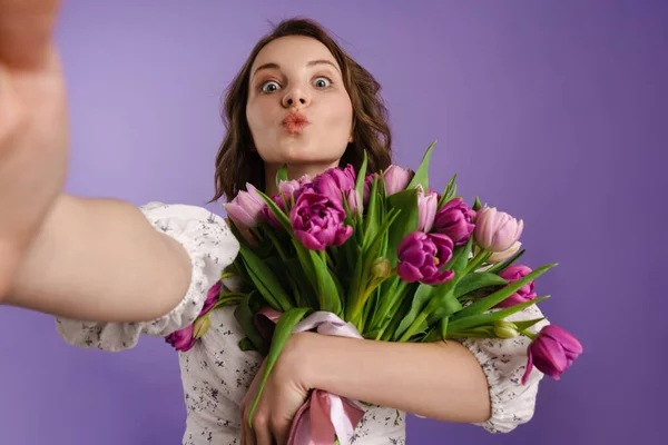 Biała Młoda Kobieta Robi Selfie Trzymając Tulipany Fioletowej Ścianie — Zdjęcie stockowe