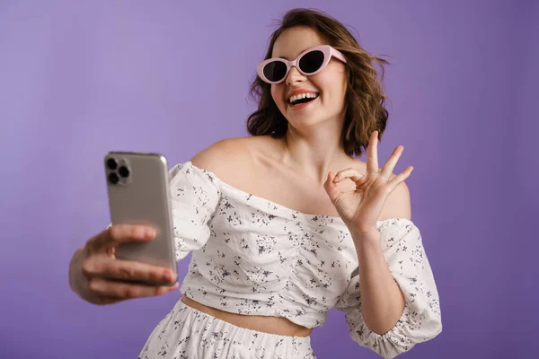 Vzrušená Žena Ukazuje Znamení Zatímco Selfie Mobilu Izolované Přes Fialovou — Stock fotografie