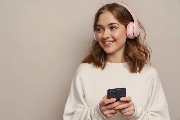 Νεαρή Χαμογελαστή Γυναίκα Ακούει Μουσική Ακουστικά Και Κινητό Τηλέφωνο Απομονώνονται — Φωτογραφία Αρχείου