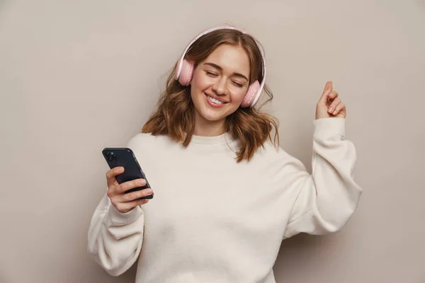 Smiling Woman Dancing While Listening Music Headphones Cellphone Isolated Grey — Stock Photo, Image