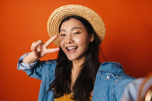 Портрет Счастливой Юной Брюнетки Азиатки Летней Шляпе Стоящей Фоне Оранжевой — стоковое фото