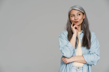 Beyaz saçlı kadının gülümseyip, gri duvarın ötesine baktığını düşünmek.