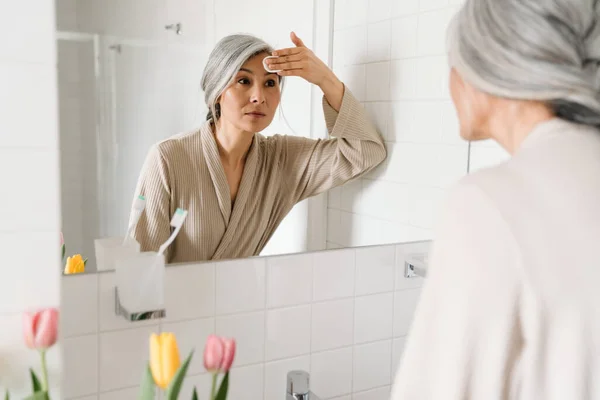 Mulher Cinza Madura Limpando Seu Rosto Com Almofada Algodão Banheiro — Fotografia de Stock
