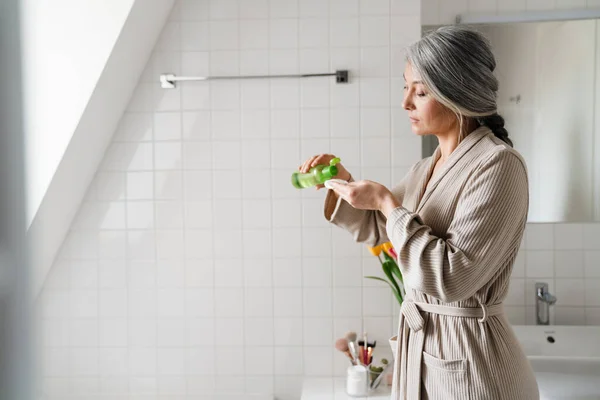 Mujer Gris Madura Limpiando Cara Con Almohadilla Algodón Baño Casa — Foto de Stock