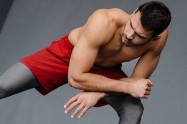 Genç üstsüz sporcu içeride çalışırken egzersiz yapıyor.