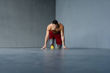 Genç üstsüz sporcu içeride çalışırken egzersiz yapıyor.