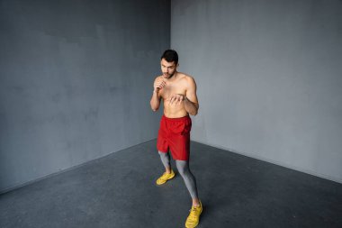 Genç üstsüz sporcu içeride çalışırken egzersiz yapıyor.