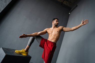 Genç üstsüz sporcu spor malzemeleriyle spor yapıyor.