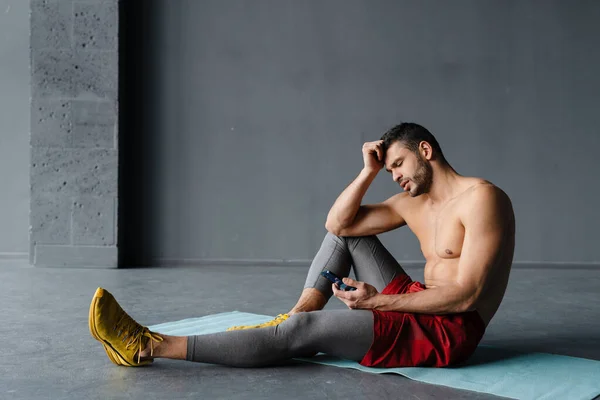 Jovem Desportista Sem Camisa Usando Telefone Celular Enquanto Trabalhava Fora — Fotografia de Stock