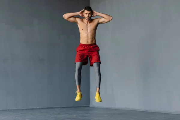 Joven Deportista Sin Camisa Saltando Mientras Hace Ejercicio Interiores —  Fotos de Stock