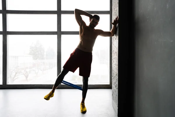 Junger Hemdloser Sportler Macht Übung Mit Expander Stretchband Innenräumen — Stockfoto