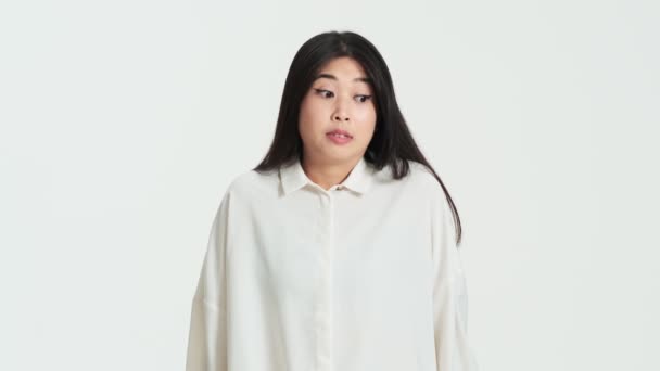 Zdezorientowana Azjatycka Koreanka Wzrusza Ramionami Stojąc Samotnie Nad Białym Tłem — Wideo stockowe
