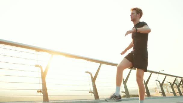 Ein Sportler Trainiert Während Seine Beine Freien Auf Der Brücke — Stockvideo