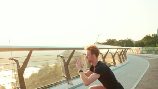 Ein Sportler Trainiert Freien Auf Der Brücke Bei Kniebeugen — Stockvideo