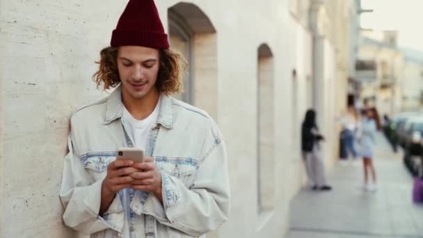 Homem Satisfeito Usando Jaqueta Jeans Usando Seu Celular Enquanto Digita — Vídeo de Stock