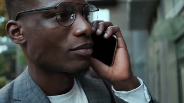 Zbliżenie Przystojnego Afrykańskiego Biznesmena Rozmawiającego Przez Komórkę Stojącego Przed Budynkiem — Wideo stockowe