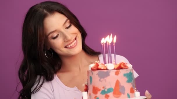 Een Gelukkig Meisje Met Een Verjaardagstaart Met Kaarsen Geïsoleerd Violette — Stockvideo