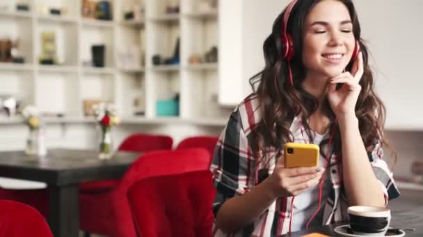 Счастливая Женщина Слушает Музыку Помощью Наушников Сидящих Кафе — стоковое видео